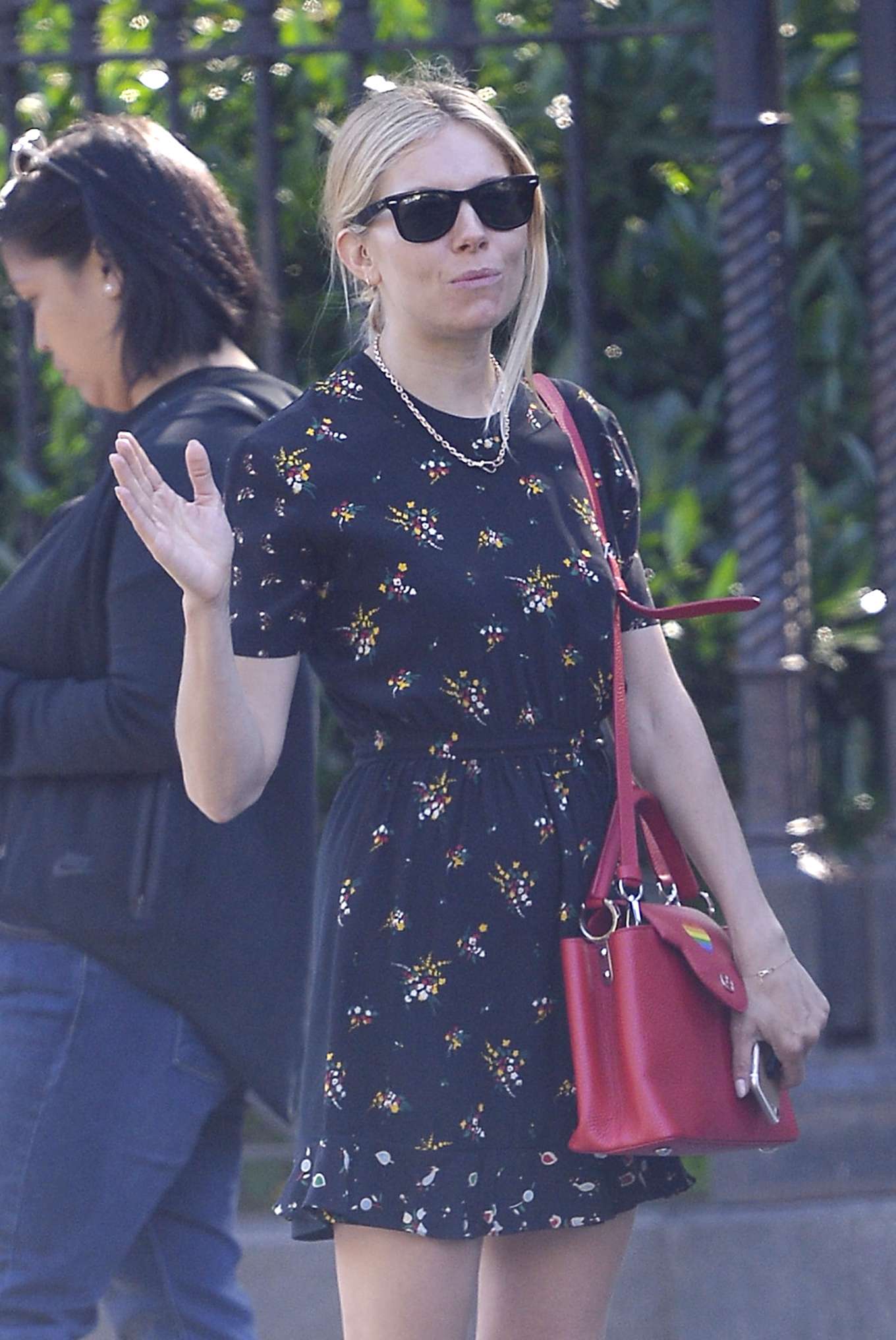 Sienna Miller – Wears a floral romper dress and fuschia shoulder bag in